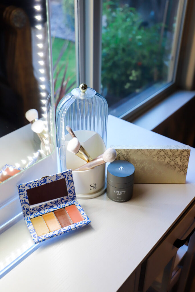 A display of a Seint makeup palette, brushes and skincare.